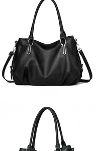 Detail of black pebbled leather handbag with dual round handles and silver metal accents