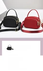 Détail d'un sac bandoulière en nylon multicouche avec ferrures dorées et sangle large