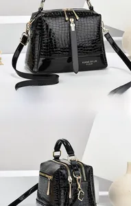 Details der schwarzen Kroko-Handtasche mit goldener Hardware und Doppelreißverschluss