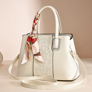 Elegant beige faux leather handbag with floral embroidery and decorative silk scarf