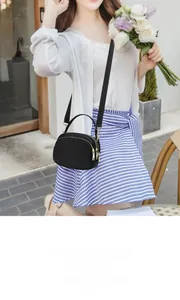 Détail du petit sac bandoulière en cuir de vachette noir avec trois compartiments zippés