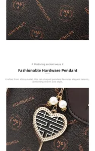 Detail of elegant heart-shaped metal charm with white pearls on a textured handbag