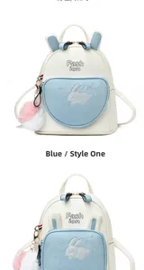 Close-up of heart-shaped blue front pocket with cute rabbit embroidery on soft leather backpack