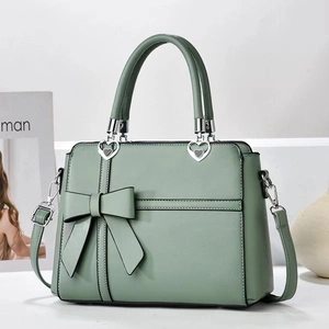 Elegant sage green handbag with bow detail and heart buckles for stylish commuting