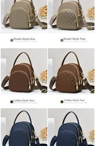 Detailed view of women's crossbody bag with three zipper layers and quilted stitching