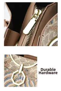 Detailed close-up of intricate oriental embroidery and durable gold hardware on handbag