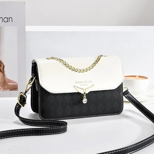 Sac bandoulière moderne contrasté noir et blanc avec texture matelassée et dorure