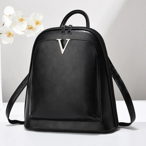 Sac à dos chic en cuir noir pour femme avec logo V argenté dans un studio minimaliste