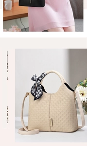 Close-up of cream woven texture handbag featuring a decorative black and white checkered ribbon