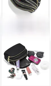 Détail du sac bandoulière noir multicouche avec trois fermetures éclair dorées et grand espace