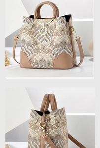 Detail of Chinese style embroidery on a beige crossbody bag with leather trim and gold rings