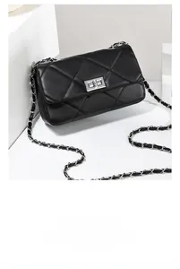 Detail of silver twist lock and black quilted leather on a mini crossbody chain bag