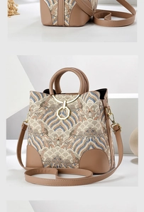 Close-up of vintage embroidery texture and premium leather handles on a shoulder bag
