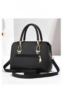 Detail of black pebbled leather bag with gold hardware and anti-theft back pocket