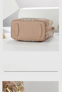 Detail view of the embroidered handbag base with protective leather pads and gold D-rings