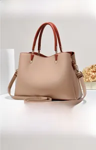 Vista laterale della borsa in pelle beige con manici marroni e dettagli dorati