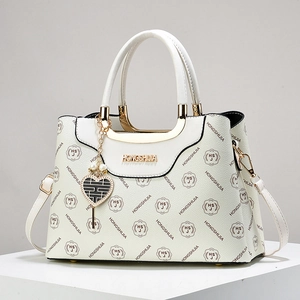 Elegant white litchi leather handbag with golden hardware and heart pendant accessory