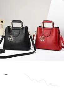 Detail of faux leather handbags with contrast geometric patterns and pearl floral charms
