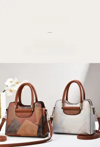 Detailed view of color-block tote bag with leather texture and elegant metal hardware