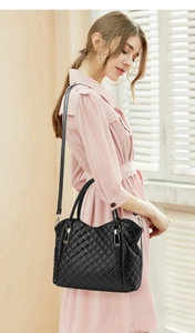 Detail of black quilted leather handbag showing large capacity and gold metal hardware