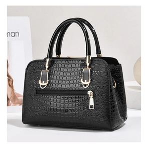 Detailed close-up of black crocodile pattern handbag with golden zipper and metal hardware