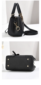 Side view and bottom of black lychee grain leather handbag with gold protective studs