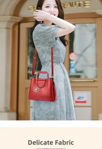 Close-up of red crocodile pattern handbag with gold camellia charm and woven handle