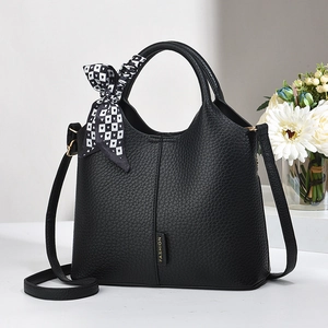 Black pebble leather tote bag with a heart silk scarf and golden fashion logo detail