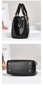 Detail of crocodile pattern handbag showing side profile and bottom metal studs