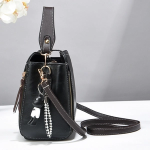 Classic black and brown leather bucket bag with cute bear charm and checkerboard tassel