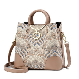 Retro jacquard tote bag with wave pattern and tan leather handles on white backdrop