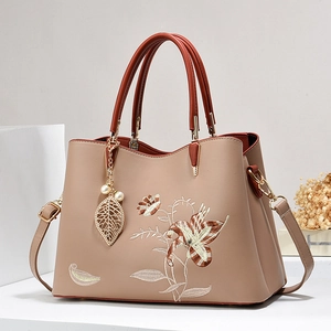 Elegante borsa tote kaki con ricamo floreale e ciondolo di perle su sfondo geometrico
