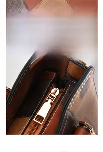 Detail of color-block tote bag featuring multi-layer plated gold zipper and secure magnetic snap