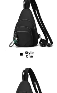 Close-up of black nylon sling bag featuring double zippers and a green star charm