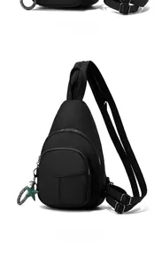 Close-up of black oxford fabric sling bag with multiple zippers and star pendant detail
