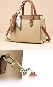 Detail of high-quality gold-tone metal hardware and hooks on women's contrast handbag