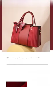 Detail of red textured tote bag featuring a decorative silk scarf and pearl charms