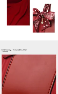 Detail of red textured leather handbag with polka dot scarf and golden pearl charm