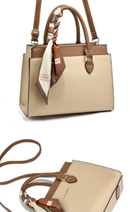 Detail of elegant two-tone tote bag with decorative silk scarf and adjustable strap