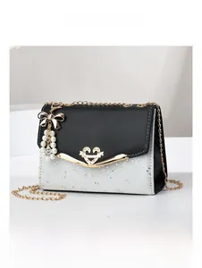 Detail view of fashion quilted bag with gold heart buckle and pearl bow charm