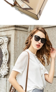 Detail of khaki leather tote bag featuring a stylish printed silk scarf on the handle