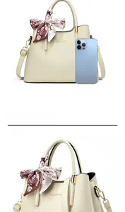 Size comparison of beige handbag with silk scarf handle next to a blue smartphone