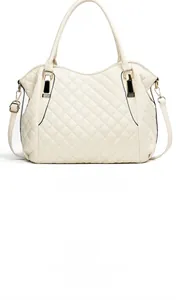 Detail of cream quilted tote bag with golden hardware and black edge paint finish