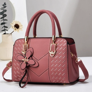 Elegant mauve leather handbag for women featuring quilted embroidery and floral charm detail