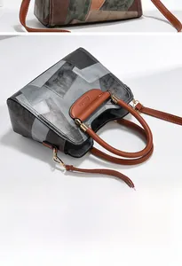 Detail of retro color-block handbag with dual handles and gold-tone metal hardware