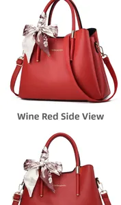 Detail view of burgundy tote bag with pebble texture, silk scarf, and crossbody strap