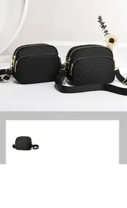 Close-up of black nylon crossbody bags with gold zippers and multi-layer storage compartments