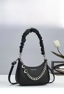 Detail of black lychee grain hobo bag with ruched handle and silver moon chain decor