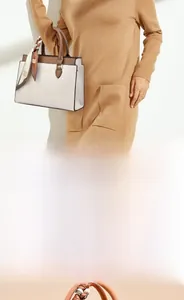 Detail of elegant two-tone tote bag with a floral scarf on the handle and logo branding