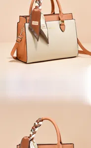 Detail of two-tone handbag with decorative scarf and golden logo on smooth leather
